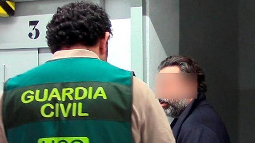 Un agente de la Guardia Civil, con el detenido.