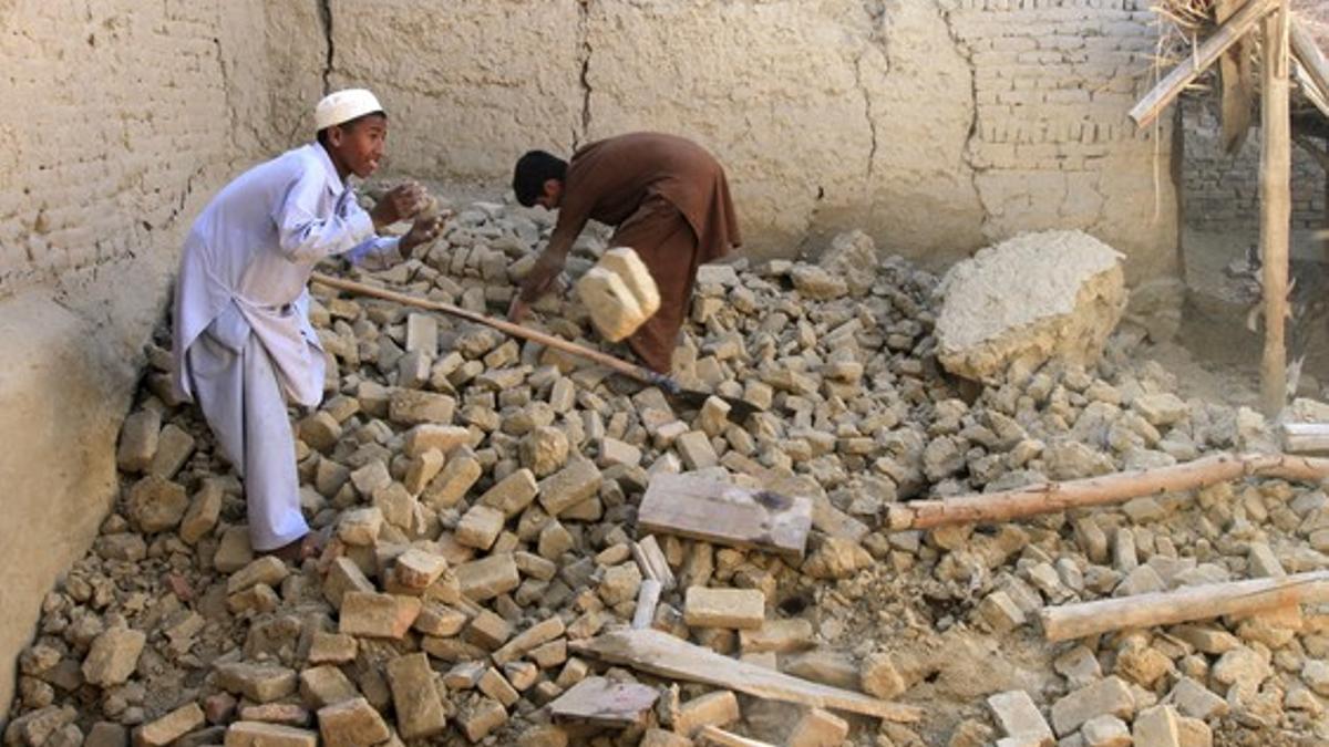 Afghan men clears bricks from a house after it was damaged by an earthquake in Behsud district of Nangarhar province, Afghanistan