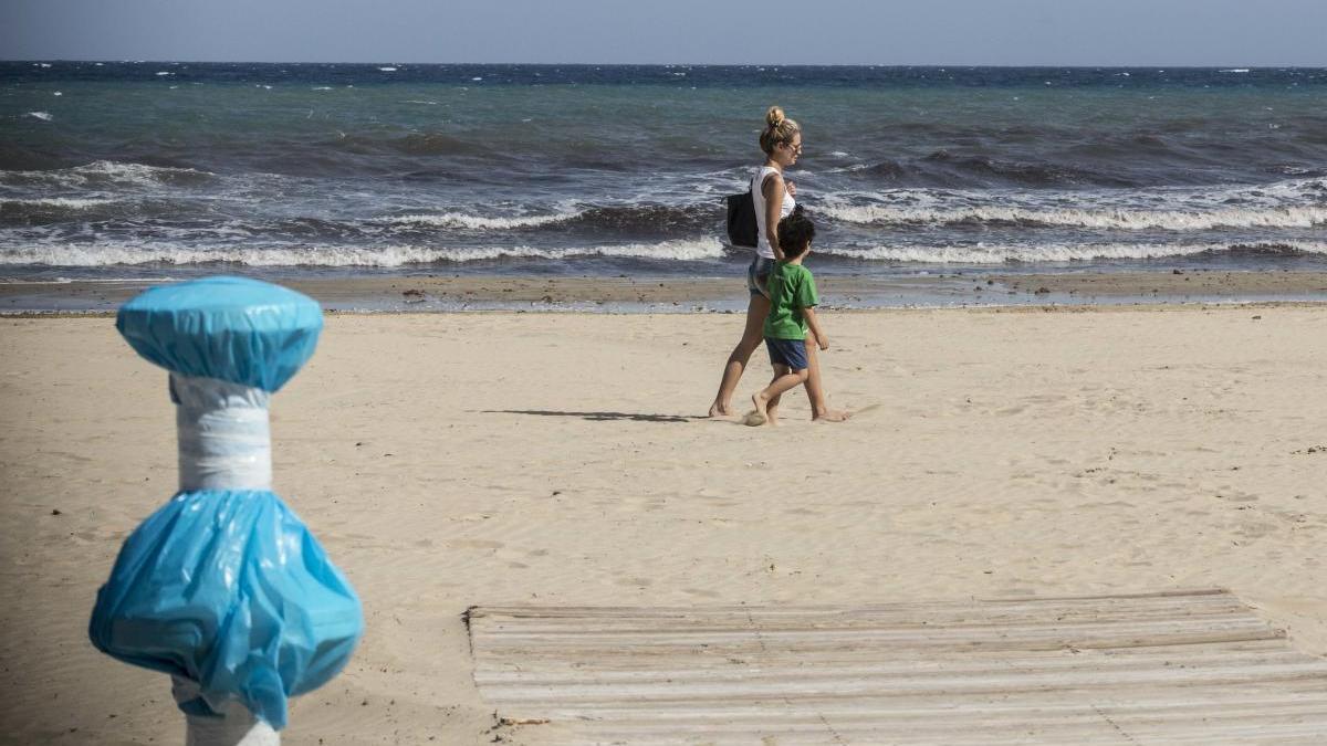 Una madre y su hija pasean por la playa