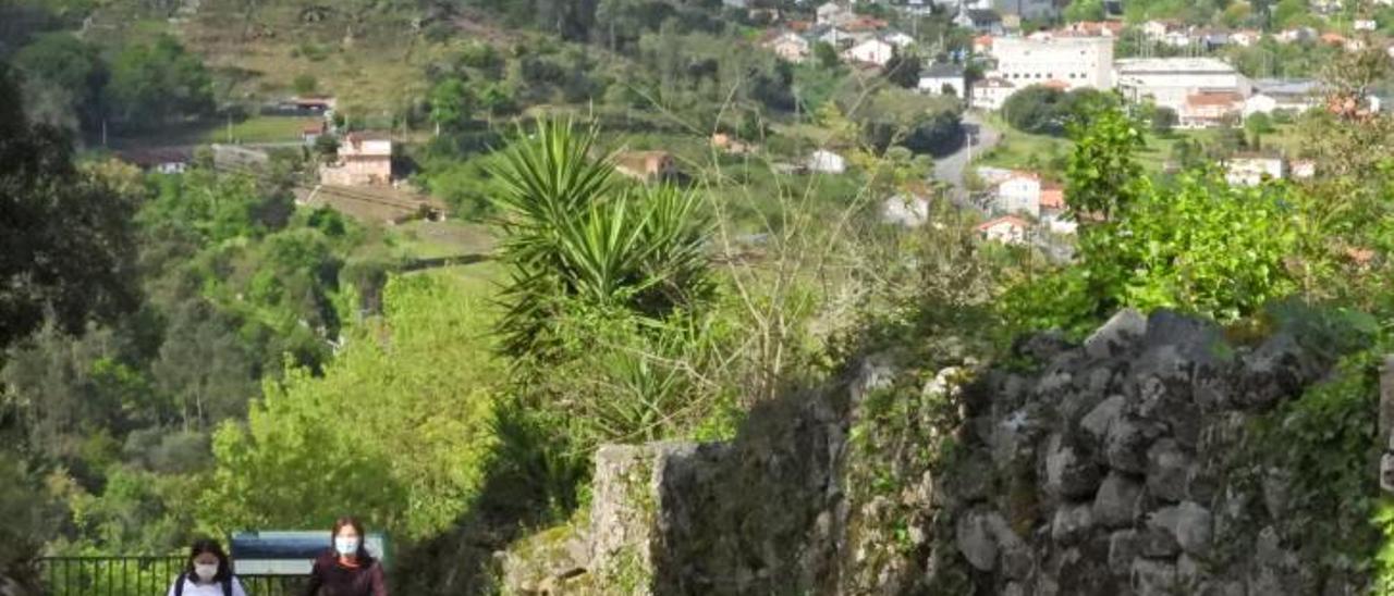 Dos personas caminan por el entorno del castro de Santomé, en Ourense.   | // FERNANDO CASANOVA