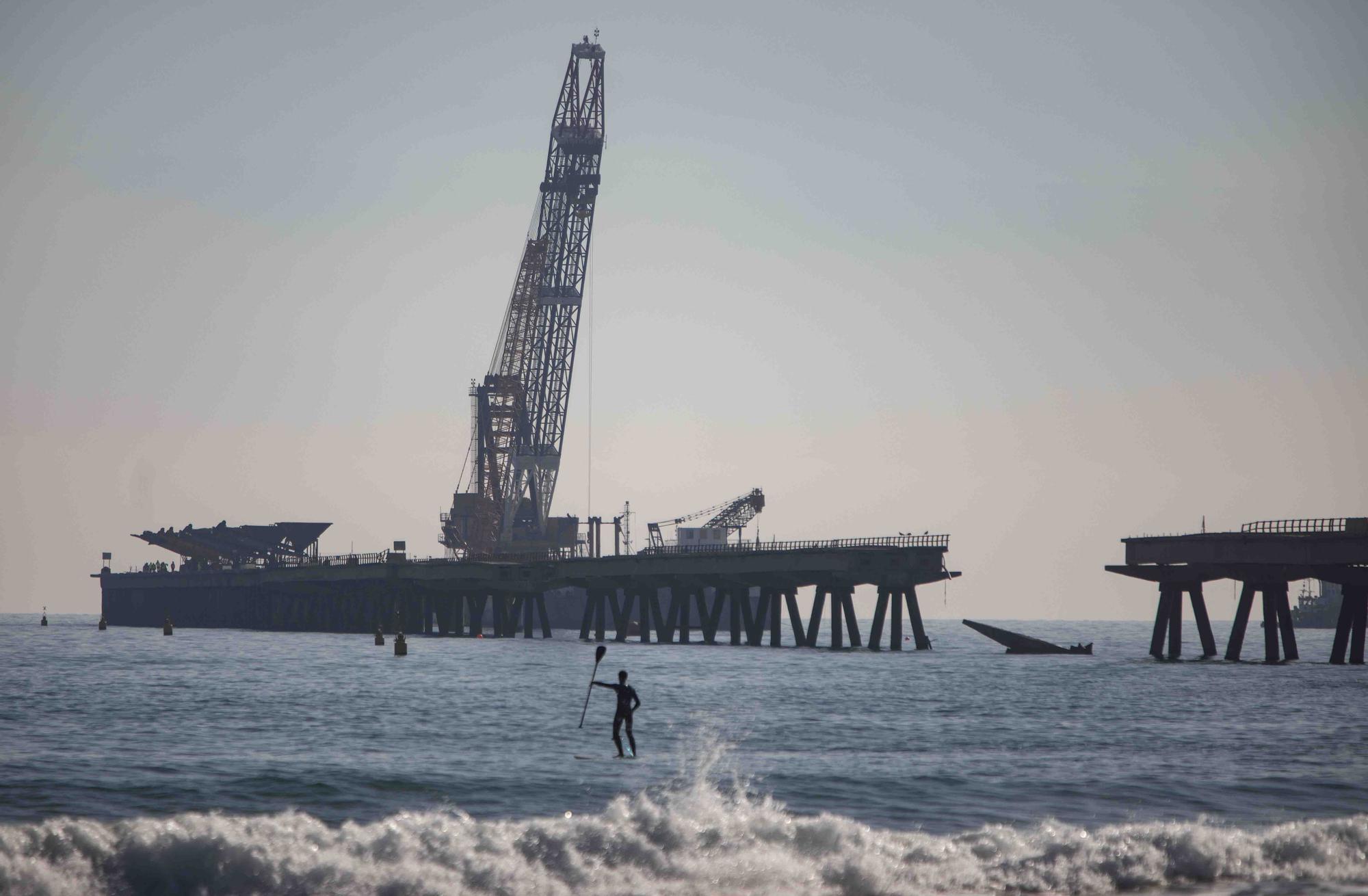 Vecinos del Port de Sagunt observan desde la playa la retirada de las tolvas del Pantalán