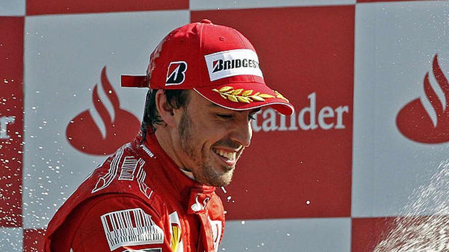 Fernando Alonso empapa de champán a sus mecánicos.