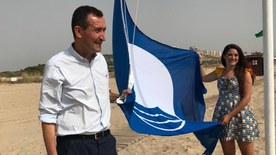 El alcalde, Carlos González, y la edil de Turismo, Mireia Mollà, izan la bandera azul de la playa de El Carabassí