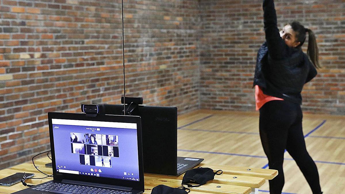 La monitora de zumba, Tania Martín, con las seis primeras alumnas “online”, ayer en el pabellón. |   // J. LORES