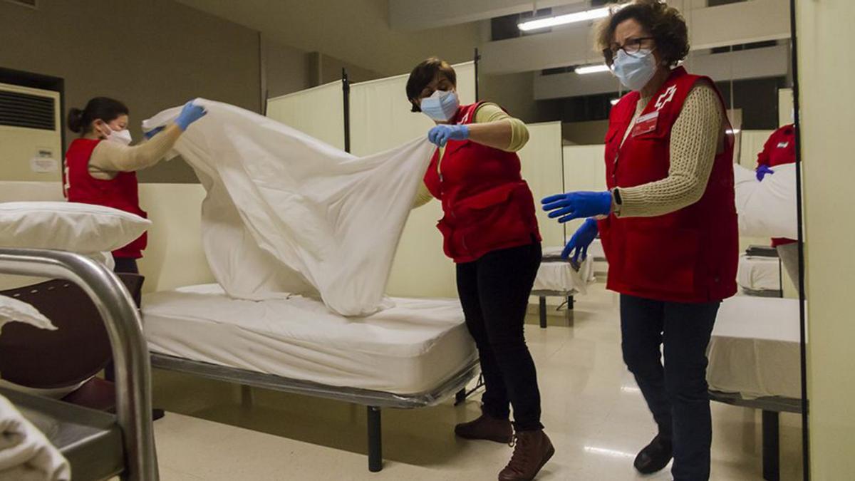 Voluntarias de Cruz Roja preparan las camas del CAES. | LEVANTE-EMV