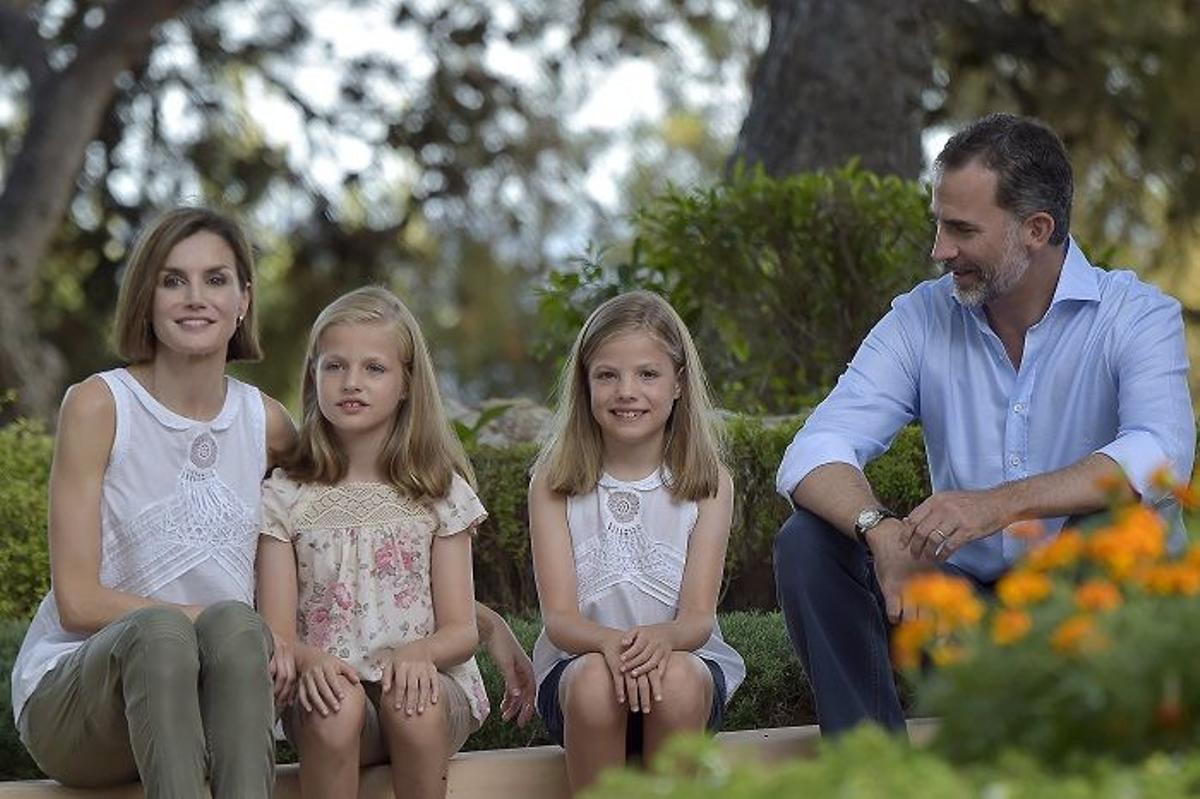 El rey Felipe mirando y sonriendo a sus hijas y la reina