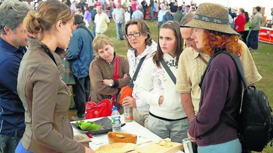 Asistentes atienden a una elaboradora de queso casín en la pasada edición del certamen de la Collá d&#039;Arniciu.