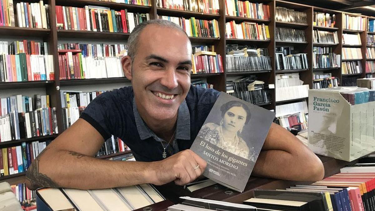 El autor, Santos Moreno, con su novela en la librería Proteo.