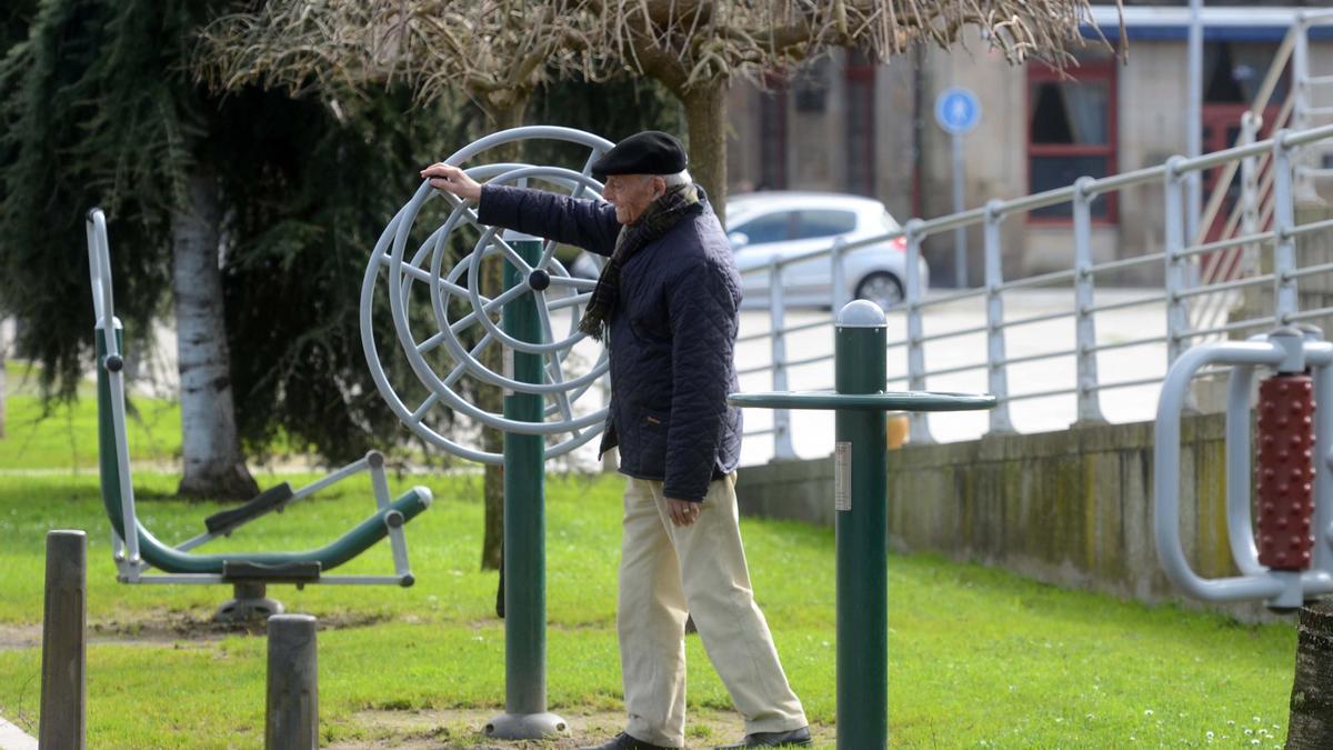 Una persona mayor hace ejercicio en un parque público.