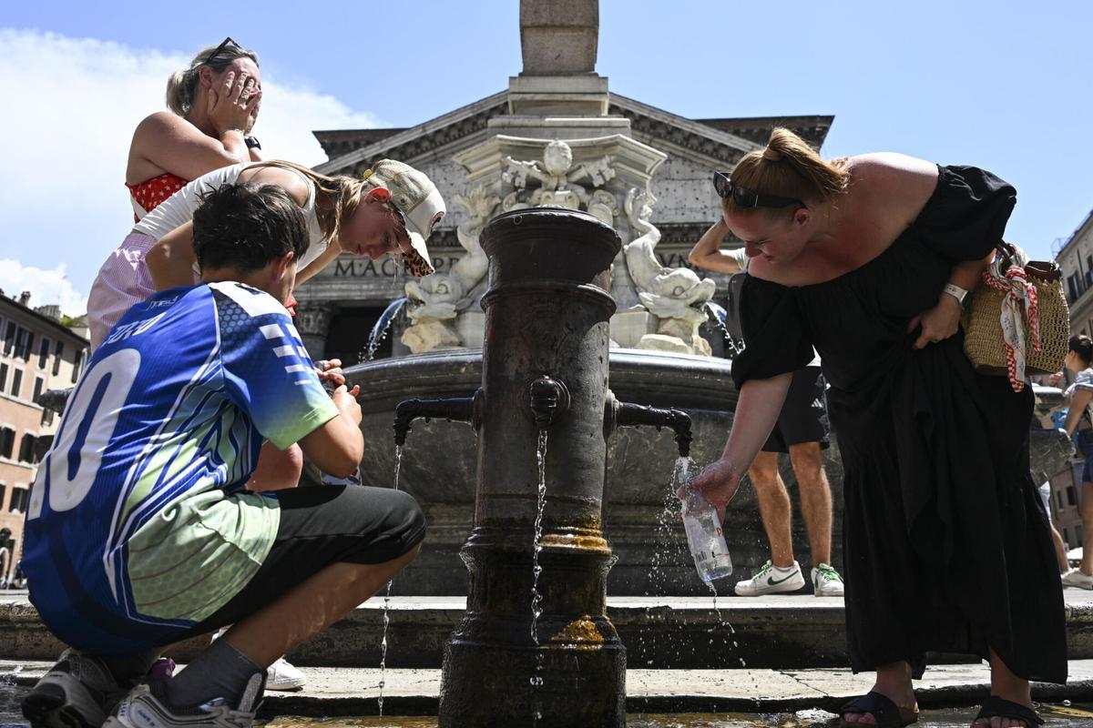 Varios turistas se refrescan en una fuente frente al Panteón, en Roma.