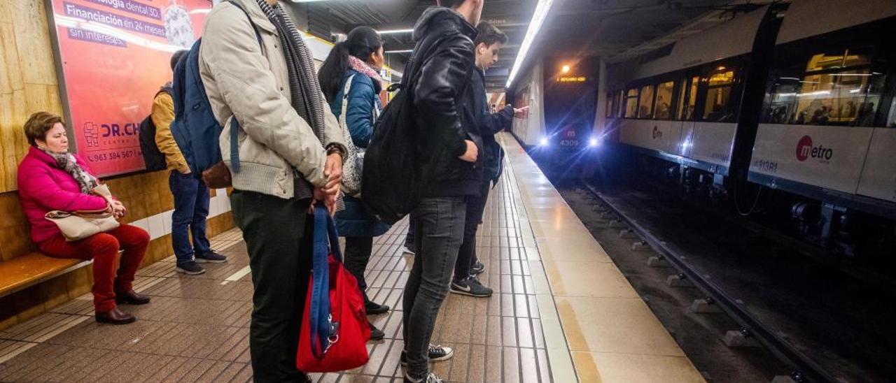 Varias personas esperan la llegada del metro en València, en una imagen de archivo.