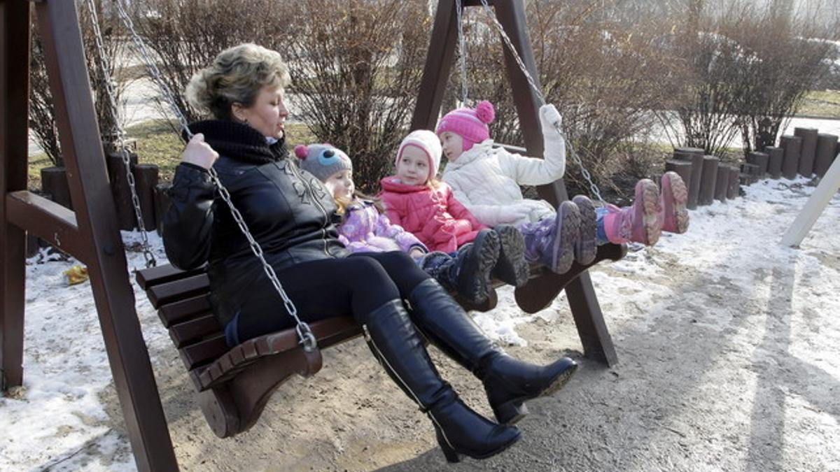 Una mujer y tres niños disfrutan del día de sol, sin bombas, en Donetsk.