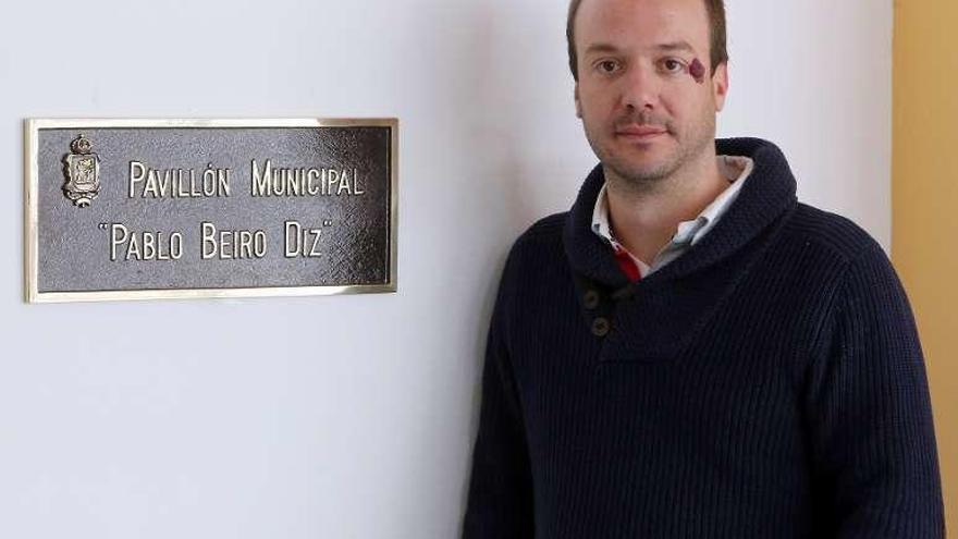 José Antonio Beiro, junto a la placa dedicada a su tío en el pabellón de Bouzas, que lleva su nombre desde enero. // Marta G. Brea