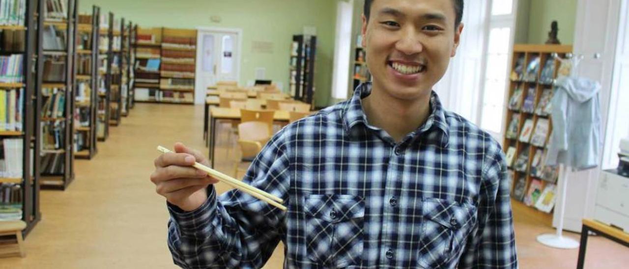 Yu Liu, en la biblioteca de Castropol, con unos palillos chinos.