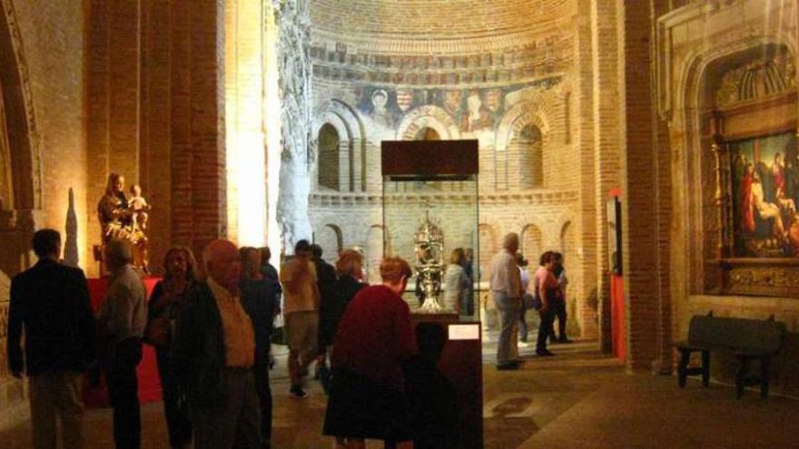 Visitantes recorren la iglesia de San Lorenzo el Real y admiran las obras de arte expuestas en su interior.