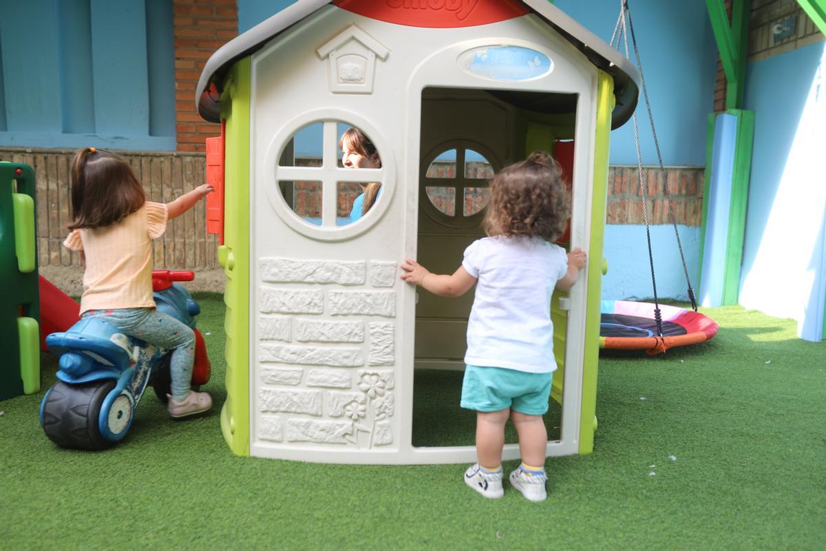 Una niña investiga dentro de una casita en el centro de educación infantil.