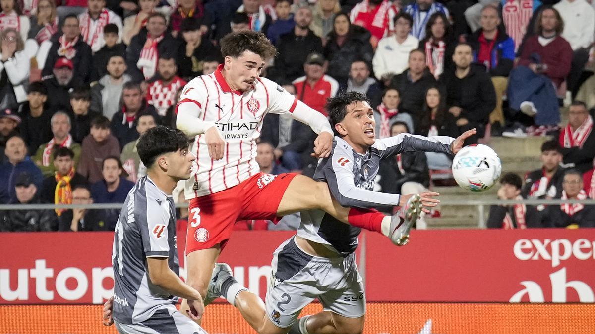 Joel Roca lluita amb Aramburu i Martín, en el partit contra la Reial Societat
