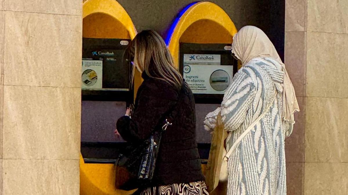 Una mujer con velo saca dinero en un cajero de Murcia este viernes.