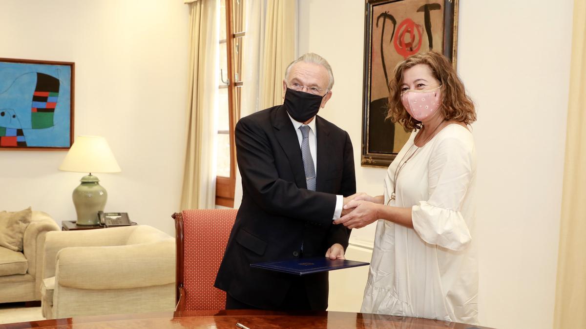 El presidente de la Fundación La Caixa, Isidro Fainé, y la presidenta del Govern, Francina Armengol, se dan la mano tras firmar el acuerdo.