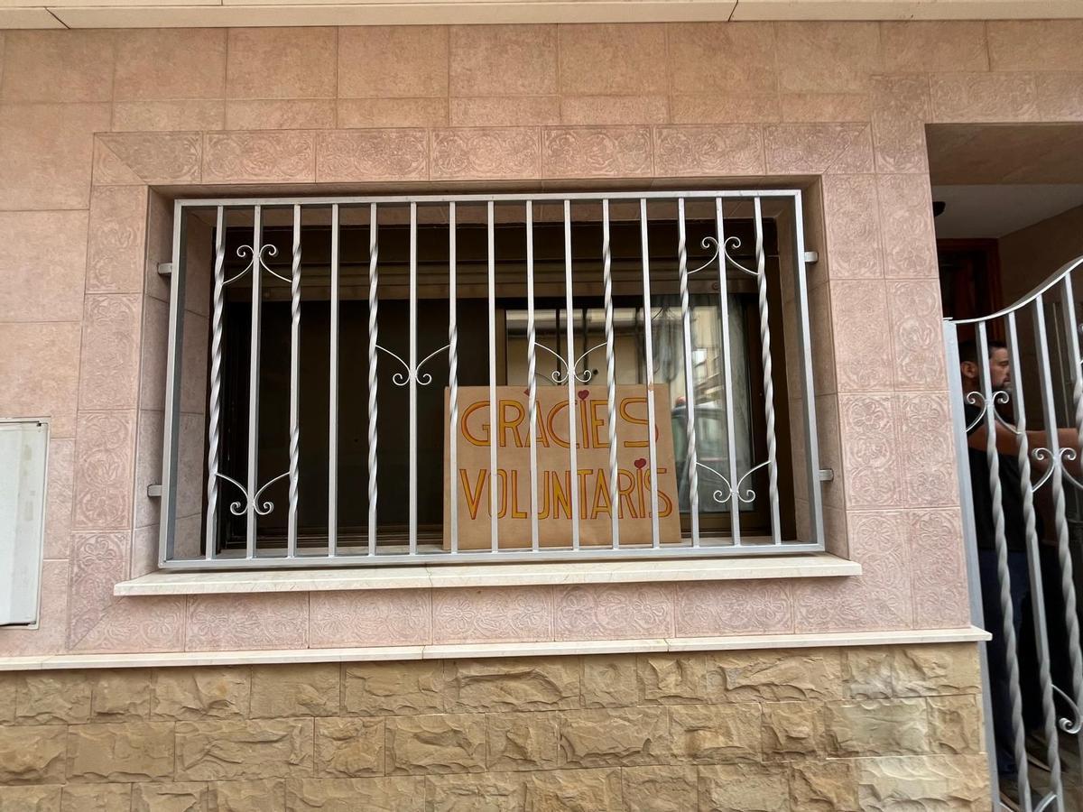 Cartel de "Gràcies, voluntaris" en la puerta de la casa de los padres de Manel.