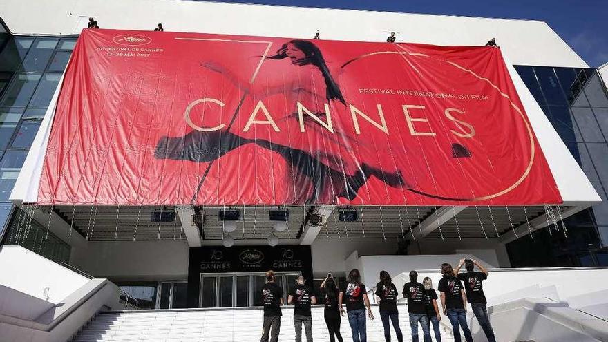 Trabajadores colocan el póster oficial del Festival de Cine de Cannes en el Palacio de los Festivales en Cannes.