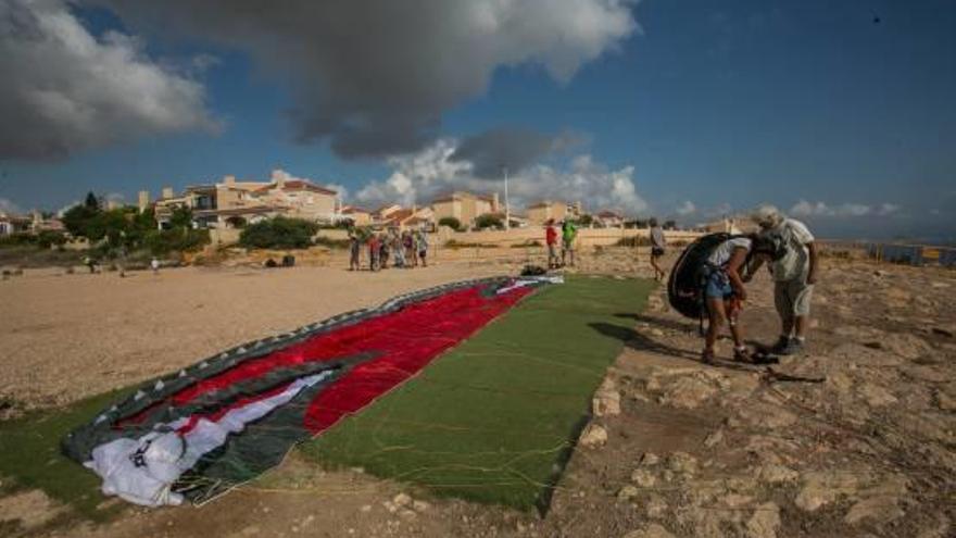 Una mujer se prepara para el despegue en parapente en la zona destinada para ello.