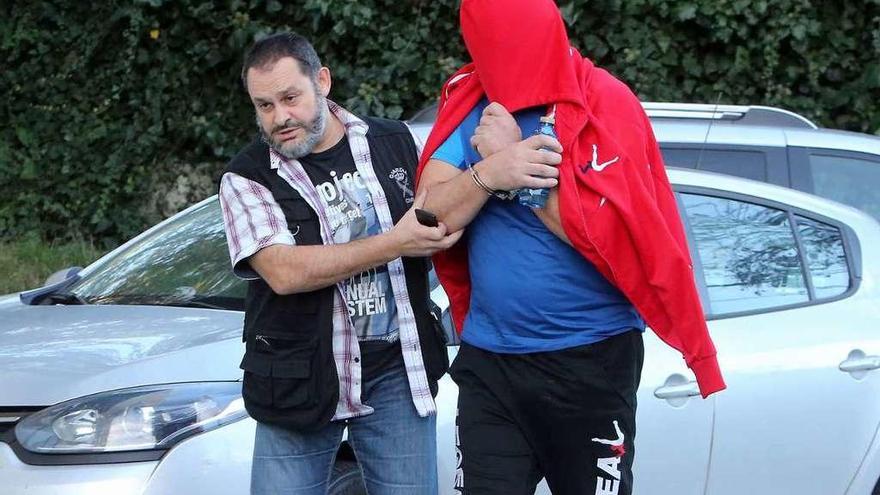 Un agente traslada a uno de los detenidos en la primera operación al juzgado.  // R. G.