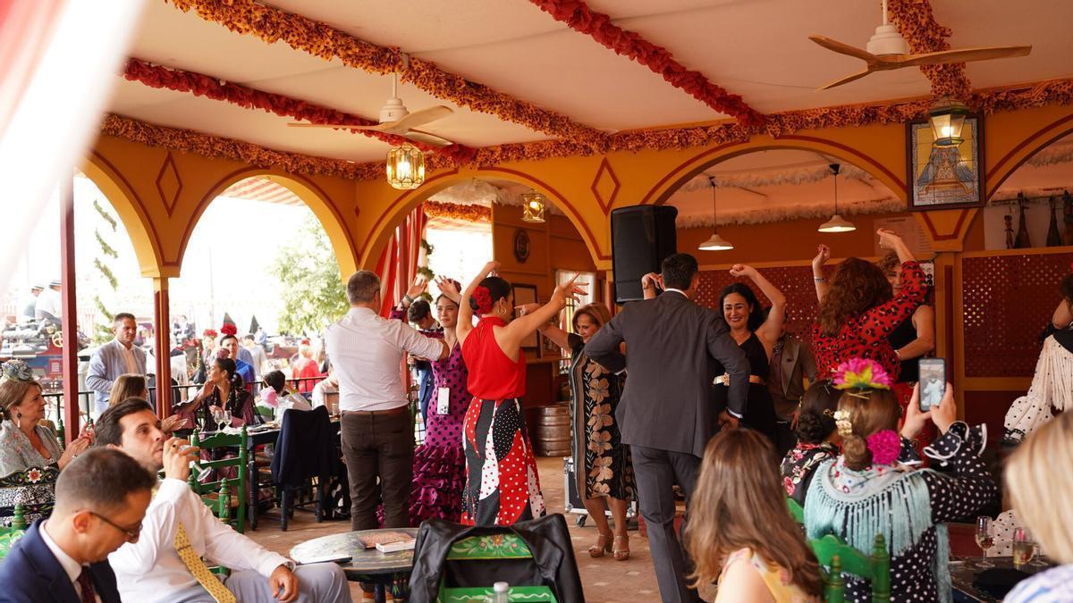 Personas bailando sevillanas en una caseta de la Feria de Abril
