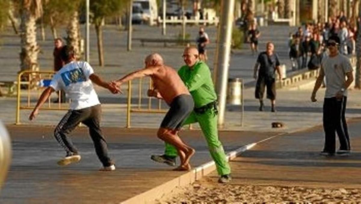 Un hombre agarra del brazo a un carterista que le ha robado sus pertenencias en la playa de la Barceloneta, el 30 de octubre.