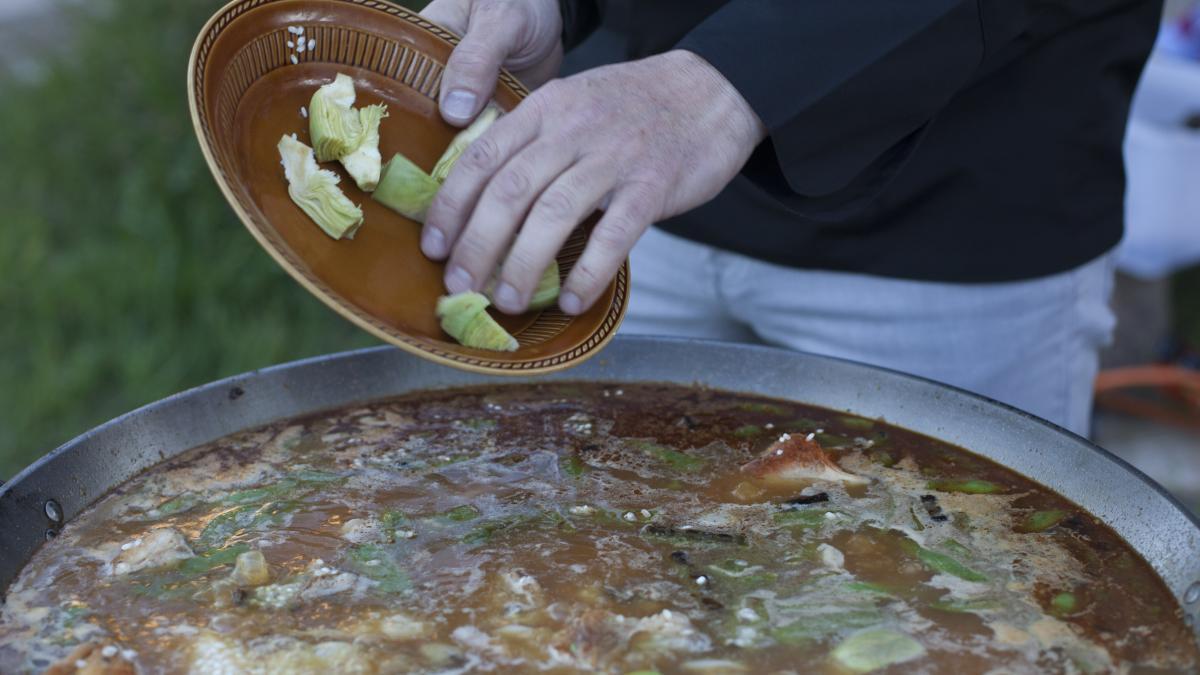 Preliminares de la paella con la verdura, el tomate y la carne.