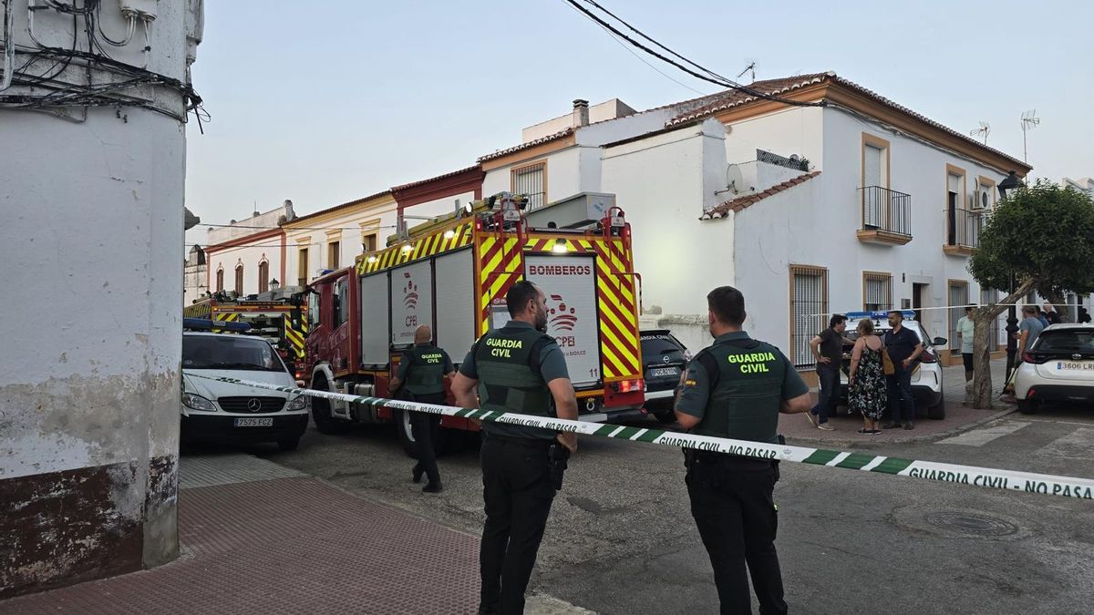 Los bomberos y la Guardia Civil, en la calle de Olivenza donde ha ocurrido el incendio.