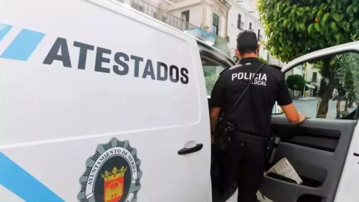 Un agente de la Policía Local de Mérida junto a un vehículo de atestados.