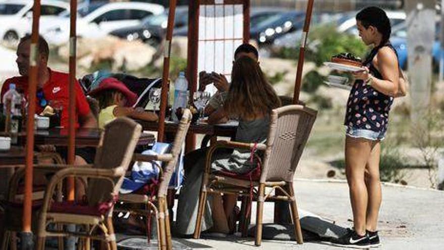 Turistas en un chiringuito de Portinatx.