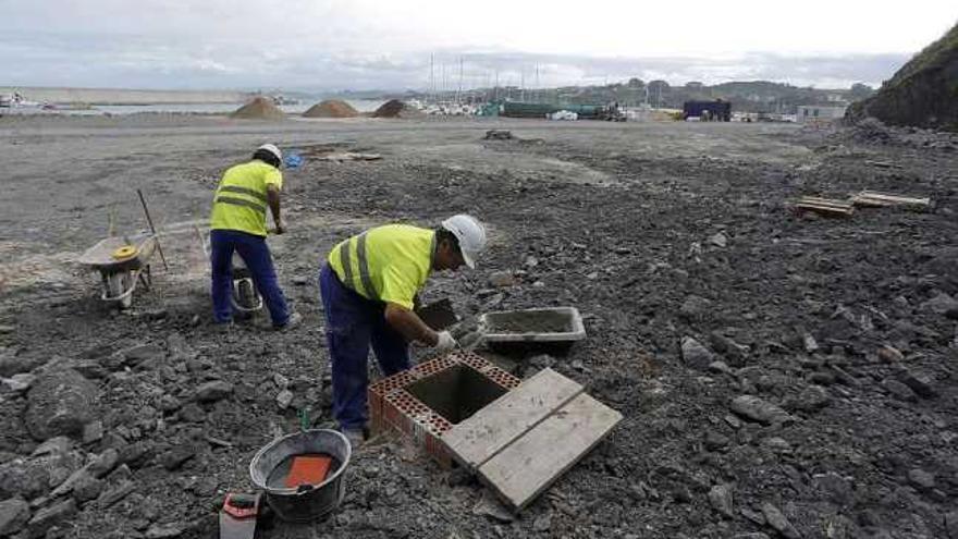 Dos trabajadores ejecutan obras en el puerto del Gayo.