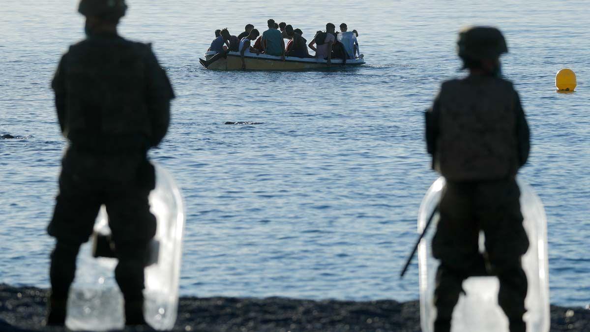 Legionarios españoles frente a migrantes marroquís en un bote.