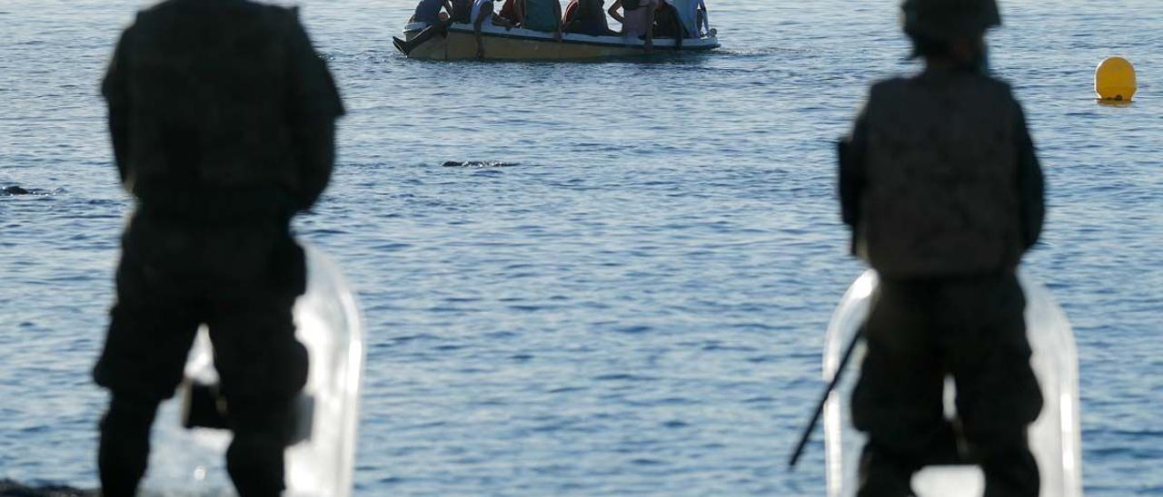 Legionarios españoles frente a migrantes marroquís en un bote.