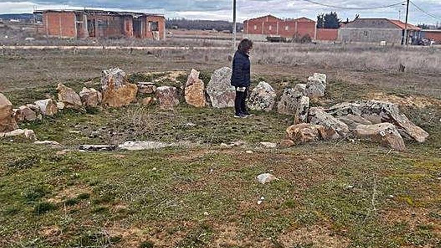 Una mujer observa el Dolmen del Tesoro en Morales de Rey.