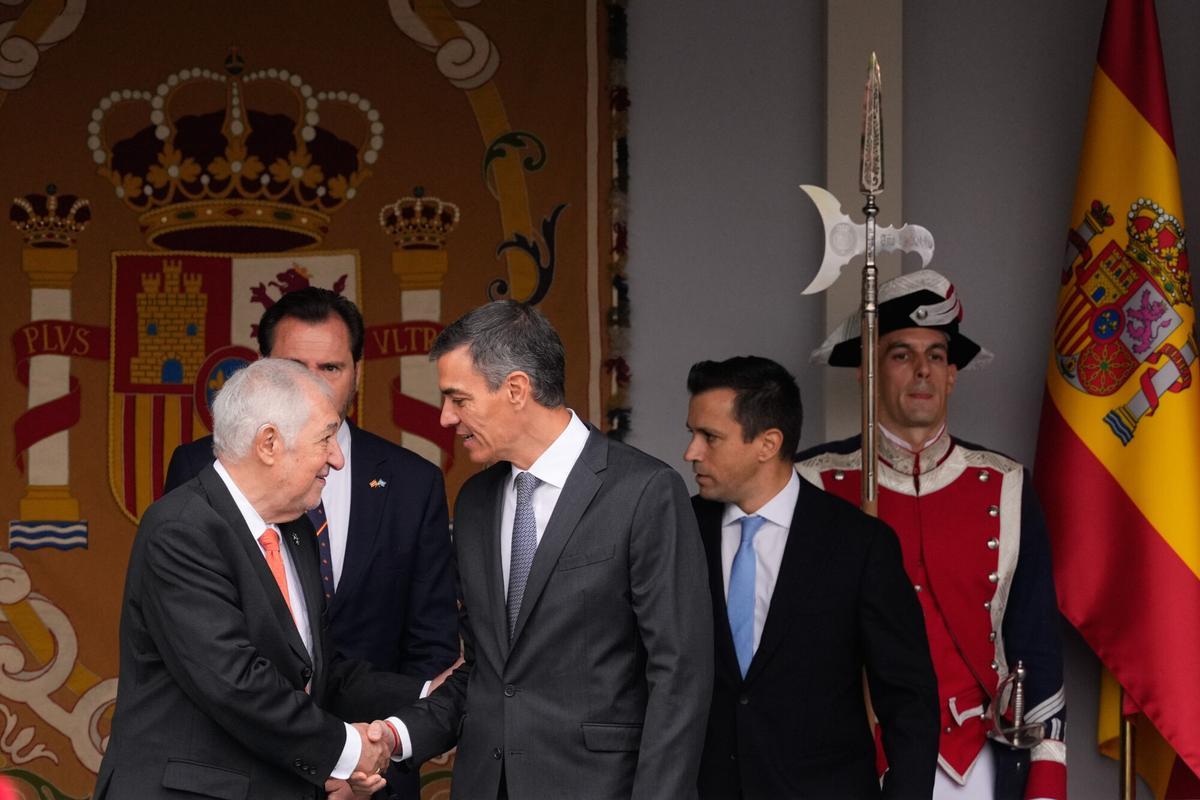 MADRID, 12/10/2025.- El presidente del Gobierno, Pedro Sánchez (c) saluda al presidente del Tribunal Constitucional, Cándido Conde-Pumpido (i), en presencia del Ministro de Transportes, Óscar Puente (2i) antes del desfile de las Fuerzas Armadas con motivo de la Fiesta Nacional este domingo en Madrid. EFE/Borja Sánchez-Trillo