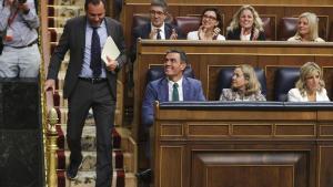 Óscar Puente pasa al lado de Pedro Sánchez antes de dar la réplica a Alberto Nuñez Feijóo en el debate de investidura.