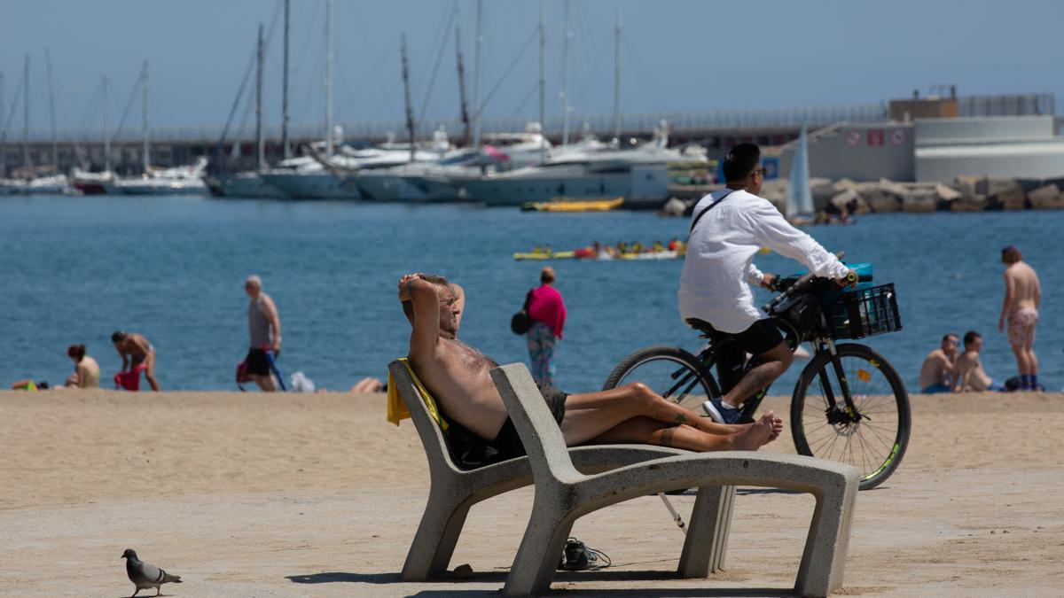 Varias personas toman el sol en la playa de la Barceloneta, a 13 de julio de 2022, en Barcelona, Catalunya (España).