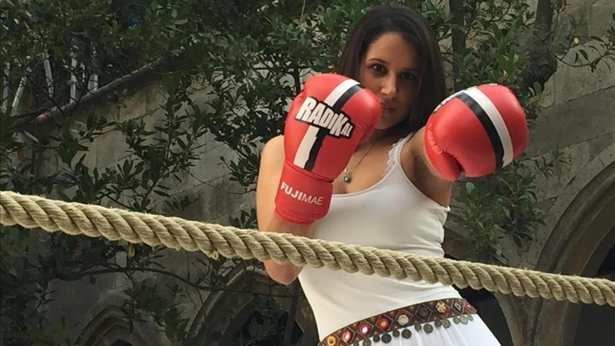 Mujer atractiva con guantes de boxeo listos para hacer ejercicio