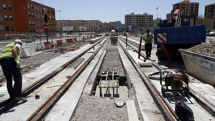 Operarios de la empresa constructora trabajan en un tramo de la plataforma del tranvía en la calle Gastón Castelló