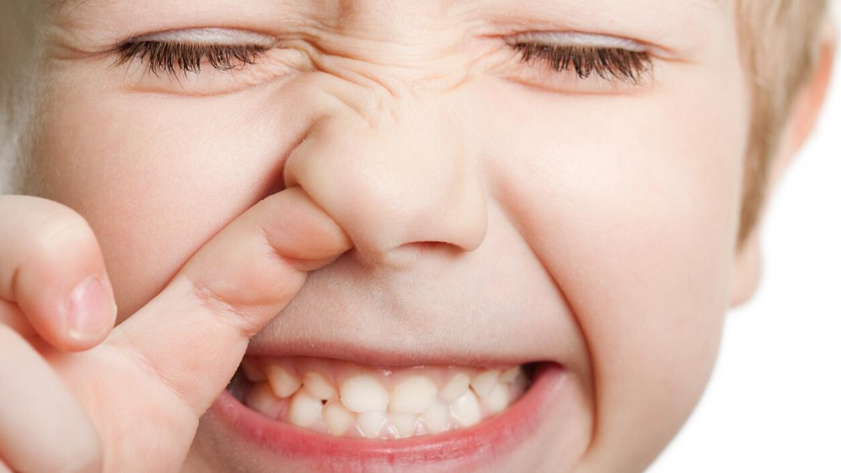 Un niño con su dedito en la nariz.