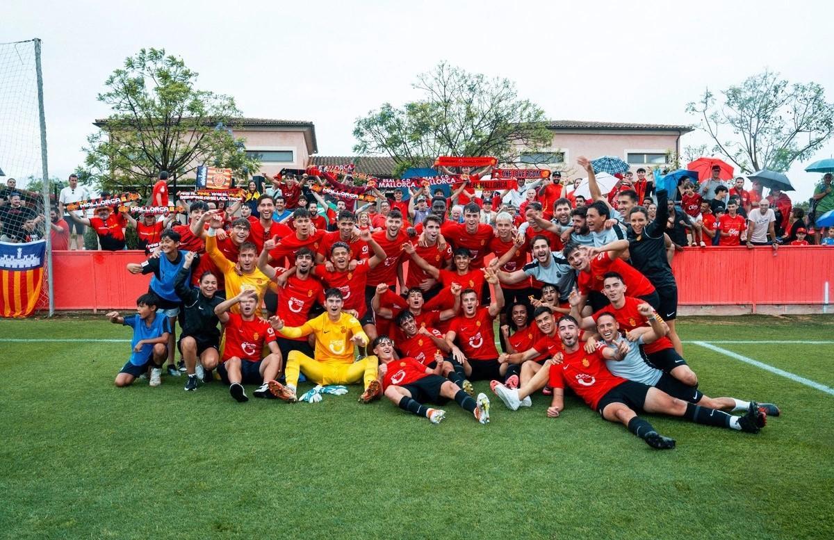 Jugadores y cuerpo técnico del Mallorca B celebran el ascenso en Son Bibiloni junto a los aficionados