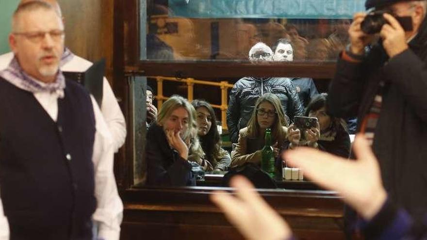 Paco Arcoiza canta mientras varios espectadores contemplan el concierto desde la terraza del local.