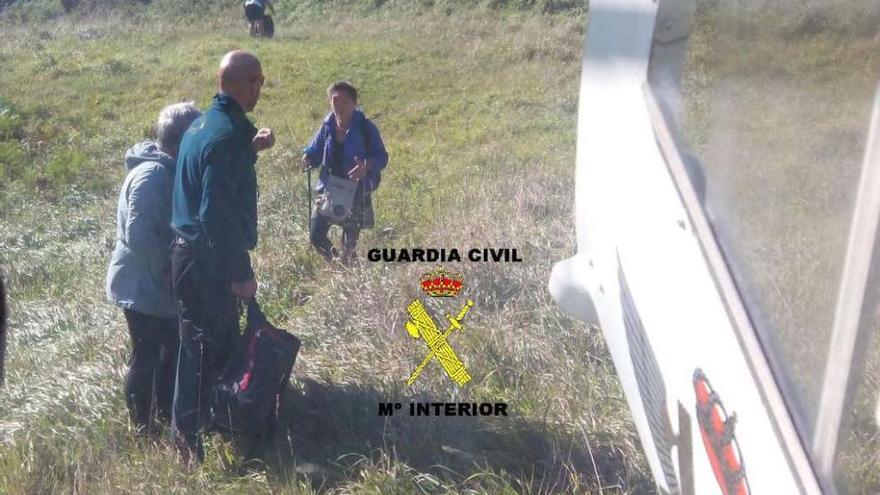 Agentes del grupo de montaña de la Guardia Civil guían a los peregrinos hacia el helicóptero.