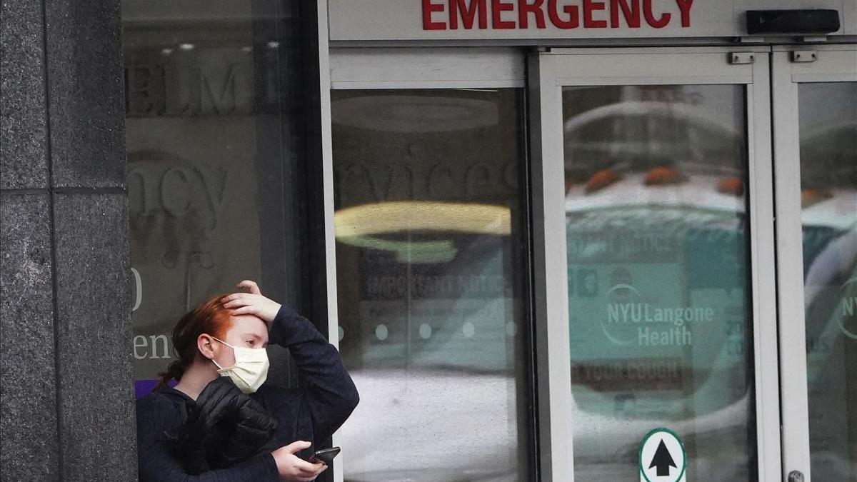 Una mujer se protege con una mascarilla en el acceso a la sala de urgencias de un hospital en Nueva York.