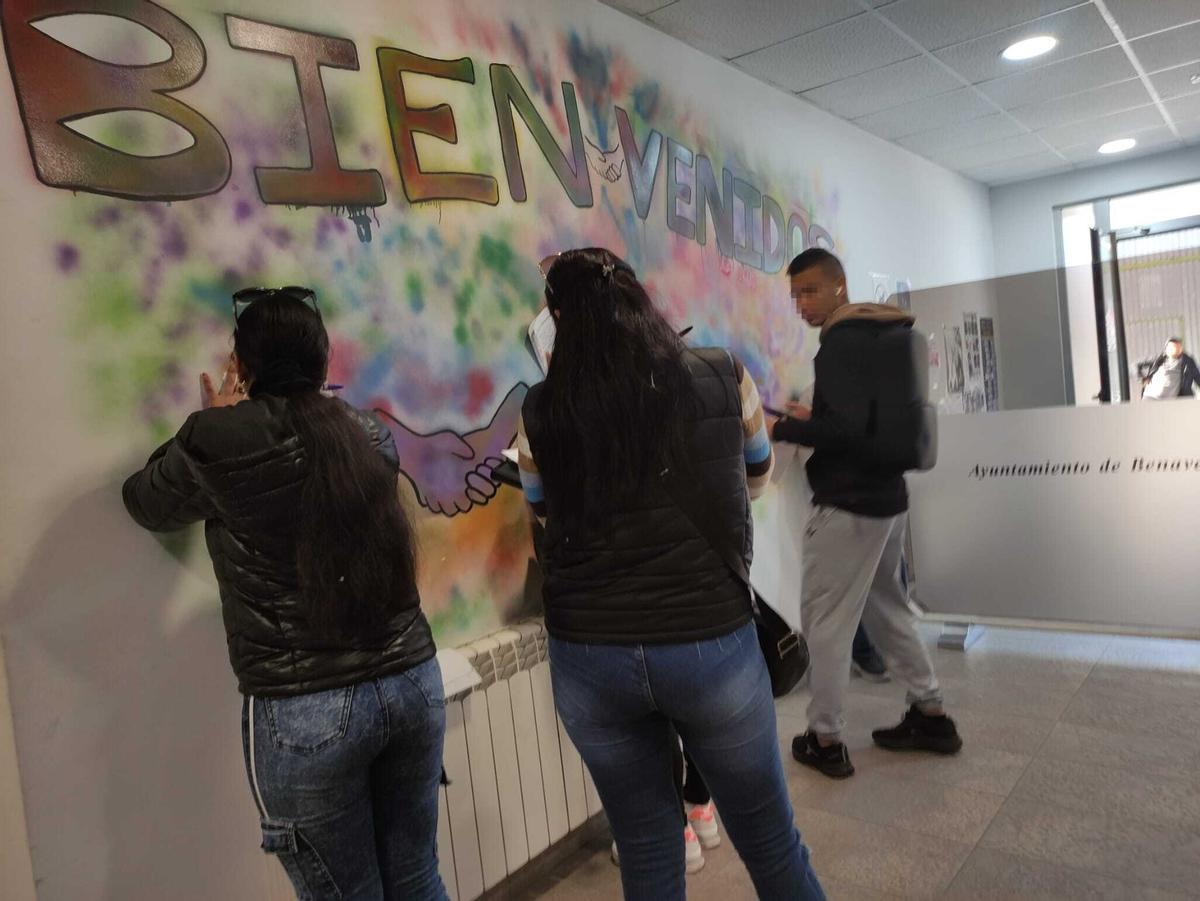 Varias personas sudamericanas rellenando la solicitud facilitada en el CMAI de Benavente.