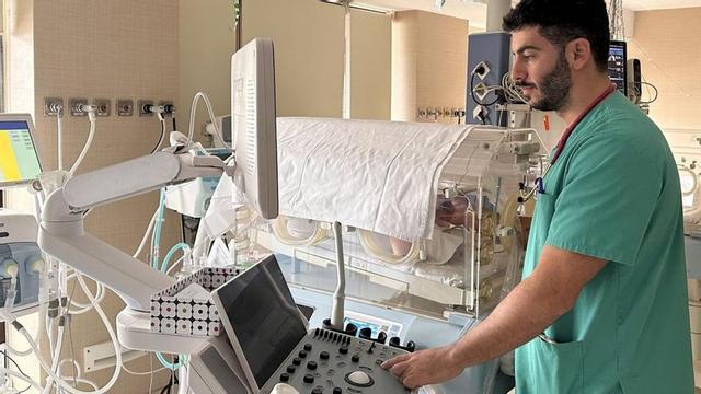 El especialista en pediatría realiza una ecografía pulmonar a un recién nacido.. lp/dlp
