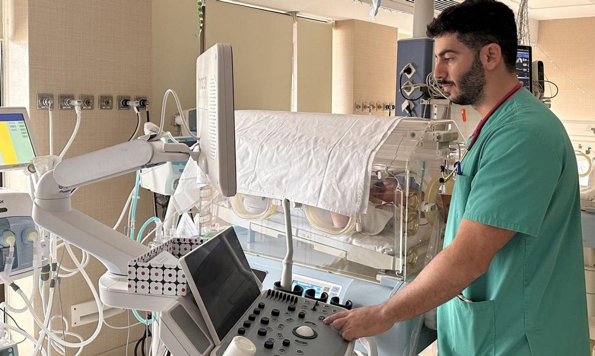 El especialista en pediatría realiza una ecografía pulmonar a un recién nacido.. lp/dlp